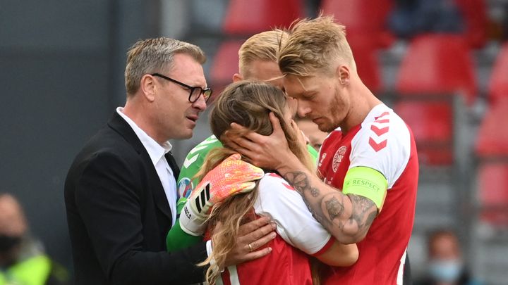 Simon Kjaer réconforte la compagne de Christian Eriksen après le malaise cardiaque de ce dernier lors du match de l'Euro 2021 entre le Danemark et la Finlande à Copenhague, le 12 juin 2021. (JONATHAN NACKSTRAND / AFP)