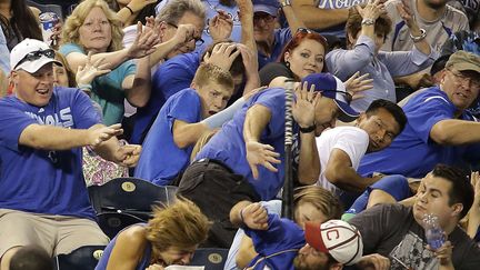 Des spectateurs d'un match de baseball tentent d'&eacute;viter une batte &eacute;chapp&eacute;e des mains d'un joueur des Texas Rangers &agrave; Kansas City (Etats-Unis), le 3 septembre 2014. (CHARLIE RIEDEL / AP / SIPA)