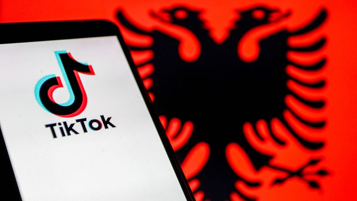 Un smartphone avec l'application TikTok et le drapeau de l'Albanie en arrière-plan (photo d'illustration). Le Premier ministre albanais a annoncé en décembre 2024 que le pays va interdire le réseau social dès le début de l'année 2025. (YASSINE MAHJOUB/SIPA)