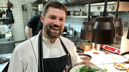 Thierry Schwartz du "Bistrot des Saveurs" à Obernai avec une assiette de chénopode, un légume feuille cousin de l'épinard (LAURENT MARIOTTE / RADIO FRANCE)