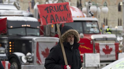 Un manifestant devant les camions stationnés devant la colline du Parlement à Ottawa, au Canada, le 3 février 2022. (ADRIAN WYLD / MAXPPP)