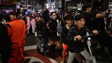 Des fêtards dans le quartier d'Itaewon, à Séoul (Corée du Sud), où a eu lieu un mouvement de foule qui a fait au moins 153 morts, le 29 octobre 2022. (ANTHONY WALLACE / AFP)