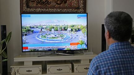 Un homme regarde un journaliste de télévision à Téhéran, en Iran, après que la télévision officielle iranienne a confirmé des "explosions massives" dans la province centrale d’Ispahan,le vendredi 19 avril 2024. (FATEMEH BAHRAMI / ANADOLU)