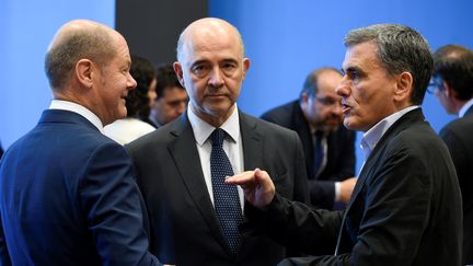 Le ministre&nbsp;allemand aux Finances, Olaf Scholz (g), avec&nbsp;le commissaire européen à l'Economie et aux Finances, Pierre Moscovici, et&nbsp;le ministre grec des Finances, Euclide Tsakalotos (D), lors de la réunion de l'Eurogroupe à&nbsp;Senningen, au Luxembourg le 21 juin 2018.&nbsp; (JOHN THYS / AFP)