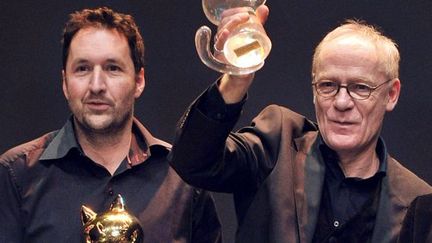 Guy Delisle (Fauve d&#039;or) et Jean-Claude Denis (Grand prix de la ville d&#039;Angoulême) avec leur trophée au Festival de la BD 2012
 (AFP/PIERRE ANDRIEU)