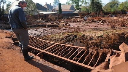 Un habitant du village de Devecser inspecte le portail de sa maison, le 11 octobre 2010. (AFP - Samuel Kubani)