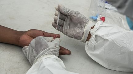 Prélèvement d'un échantillon de sang dans un centre de dépistage du coronavirus à Antananarivo, la capitale malgache, le 31 mars 2020. (RIJASOLO / AFP)