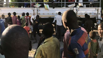 Des personnes déplacées et des habitants du village de Naunde (nord du Mozambique) déchargent un camion apportant de l'aide, le 13 juin 2018. (JOAQUIM NHAMIRRE / AFP)