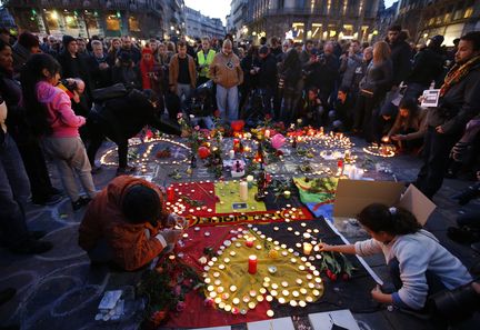 Des personnes posent des bougies en hommage aux victimes des attentats, le 22 mars 2016 à Bruxelles. (CHARLES PLATIAU / REUTERS)