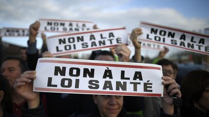 Une femme tient une pancarte "non à la loi santé", durant une manifestation des médecins à Rennes (Ile-et-Vilaine), le 13 novembre 2015. (DAMIEN MEYER / AFP)