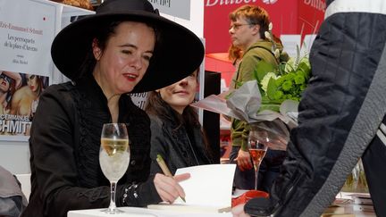 Reine du best-seller et de la d&eacute;dicace, Am&eacute;lie Nothomb se plie &agrave; l'exercice avec le sourire et une coupe de champagne, &agrave; Bruxelles, en Belgique, le 23 f&eacute;vrier 2014.&nbsp; (CITIZENSIDE/OLIVIER GOUALLEC / AFP)