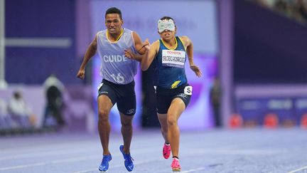 La Colombienne Ionis Dayana Salcedo Rodriguez portait une tête de chat sur les yeux lors de sa demi-finale du 400 m T11, aux côtés de son guide habillé plus sobrement. (ULRIK PEDERSEN / AFP)