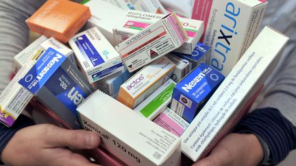 Une pharmacienne pr&eacute;sente une partie des 77 m&eacute;dicaments plac&eacute;s "sous haute surveillance" par l'Afssaps en janvier 2011. (PHILIPPE HUGUEN / AFP)