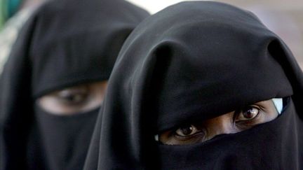 Tchadienne, revêtue de la Burqa, le voile intégral qui ne laisse voir que les yeux, faisant la queue devant un bureau de vote à N'Djamena le 3 mai 2006 pour le premier tour de la présidentielle. (AFP PHOTO/ISSOUF SANOGO)