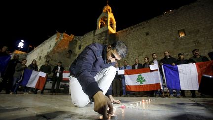 Un Palestinien allume des bougies au pied de l'église de la Nativité, en hommage aux victimes des attentats de Paris le 13 novembre ainsi qu'à celles de l'attentat de Beyrouth le 12 novembre. Deux attaques meurtrières revendiquées par l'organisation Etat islamique. (Mussa QAWASMA / REUTERS)