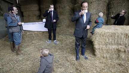 Le candidat du Parti socialiste &agrave; l'&eacute;lection pr&eacute;sidentielle Fran&ccedil;ois Hollande (3e D) d&eacute;guste un caf&eacute; au lait en visite dans une laiterie &agrave; Parn&eacute;-sur-Roc (Mayenne), le 23 f&eacute;vrier 2012. (PATRICK KOVARIK / AFP)