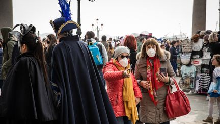 Des personnes portent des masques pendant le carnaval de Venise&nbsp; (Italie), le 23 février 2020 (MANUEL ROMANO / AFP)