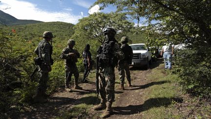 Des soldats montent la garde devant un site o&ugrave; a &eacute;t&eacute; d&eacute;couverte une fosse commune, le 4 octobre 2014, &agrave; Colonia Las Parotas (Mexique). (JORGE LOPEZ / REUTERS)