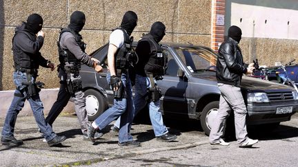 Des policiers devant l'appartement o&ugrave; a &eacute;t&eacute; donn&eacute; l'assaut contre Mohamed Merah &agrave; Toulouse, le 23 mars 2012. (JEAN-PIERRE MULLER / AFP)