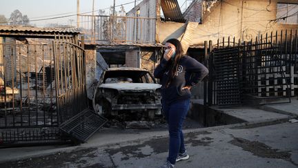 On the hills of Viña del Mar, a woman observes the extent of fire damage, February 3, 2024. (JAVIER TORRES / AFP)