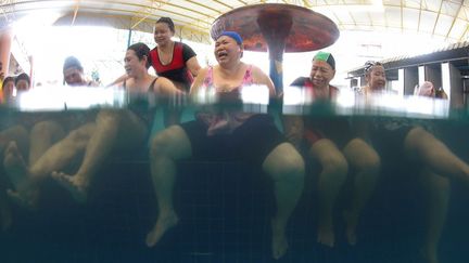 Cours d'aquagym pour personnes âgées dans une piscine privée de Bangkok. Un tiers du revenu des familles actives passe dans l'aide de leurs anciens. (Athit Perawongmetha/REUTERS)