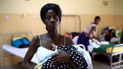 Une mère tient son bébé après l'avoir allaité au centre de santé de Kisenyi, à Kampala, la capitale de l'Ouganda, le 10 avril 2015. (JAMES AKENA/REUTERS)