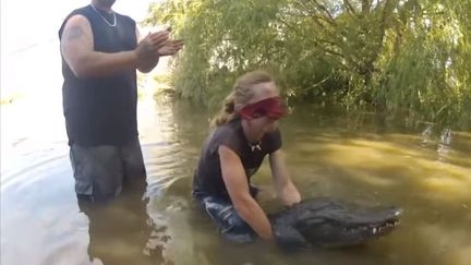 Challenge "Bad bird". Une femme avec un bandeau sur les yeux capture un alligator. (CAPTURE D'ÉCRAN YOUTUBE)