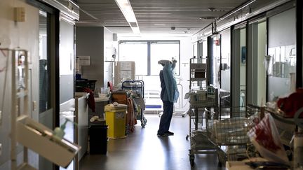 Un personnel soignant enfile une blouse jetable dans un service de réanimation de l'hôpital de la Croix-Rousse à Lyon. (MAXIME JEGAT / MAXPPP)