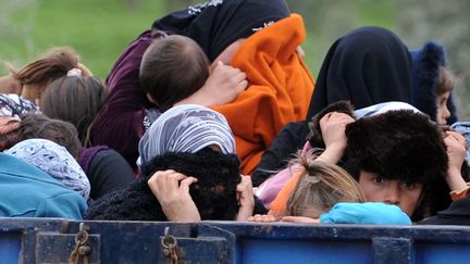 Des r&eacute;fugi&eacute;s syriens se cachent le visage &agrave; leur arriv&eacute;e &agrave; la fronti&egrave;re turque, le 15 mars 2012. (BULENT KILIC / AFP)