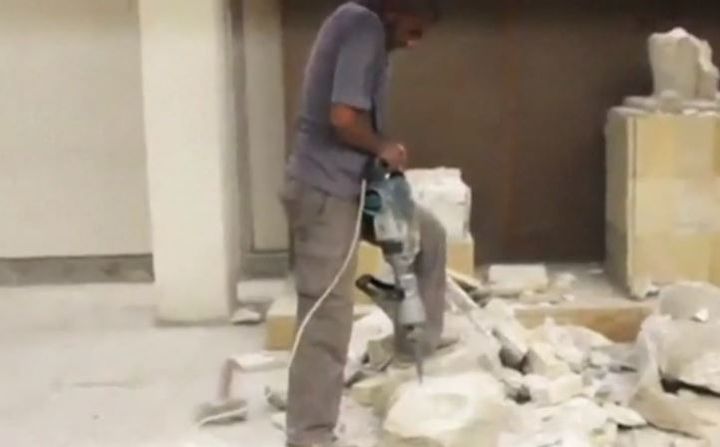 Un homme d&eacute;truit au marteau piqueur une &oelig;uvre d'art dans un mus&eacute;e de Mossoul, dans une vid&eacute;o diffus&eacute;e par l'organisation Etat islamique, le 26 f&eacute;vrier 2015. ( DR )