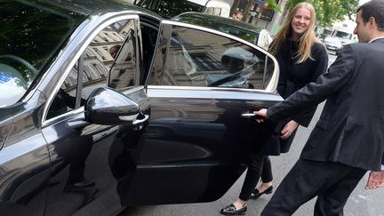 Un chauffeur de VTC ouvre la porte &agrave; une cliente, &agrave; Paris, le 24 avril 2014. (PIERRE ANDRIEU / AFP)