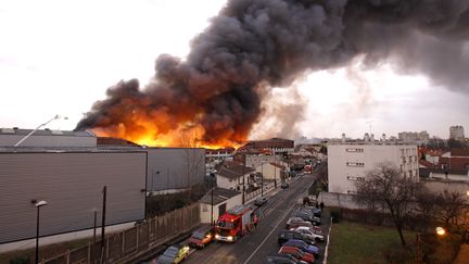 Le feu a pris vers 14 heures dans un entrep&ocirc;t de textile et chaussures de 10 000 m2 &agrave; La Courneuve (Seine-Saint-Denis). (BENOIT TESSIER / REUTERS)