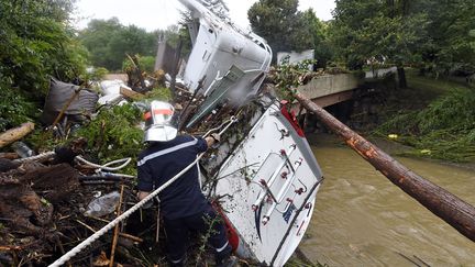 Un pompier se tient pr&egrave;s d'un v&eacute;hicule o&ugrave; deux corps ont &eacute;t&eacute; trouv&eacute;s &agrave; Lamalou-les-Bais, dans l'Herault, le 18 septembre 2014. (PASCAL GUYOT / AFP)