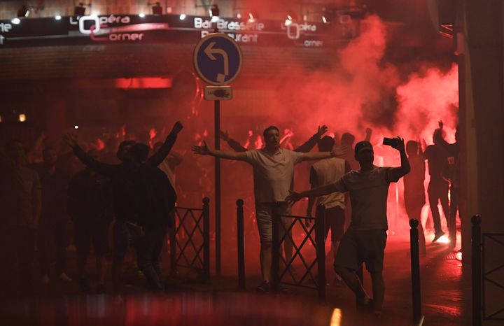 Des supporters anglais chantent après avoir allumé un fumigène, dans une rue menant du théâtre à la gare, mercredi 15 juin 2016, à Lille (Nord). (MARIUS BECKER / DPA / AFP)