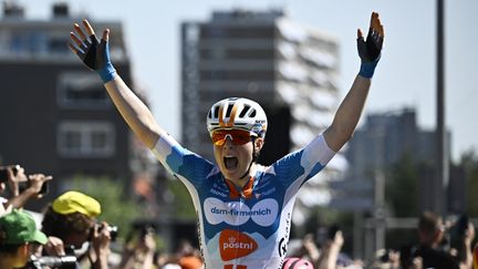 La Néerlandaise Charlotte Kool lève les bras lors de l'arrivée de la 1re étape du Tour de France femmes, le 12 août 2024 à La Haye (Pays-Bas). (JULIEN DE ROSA / AFP)