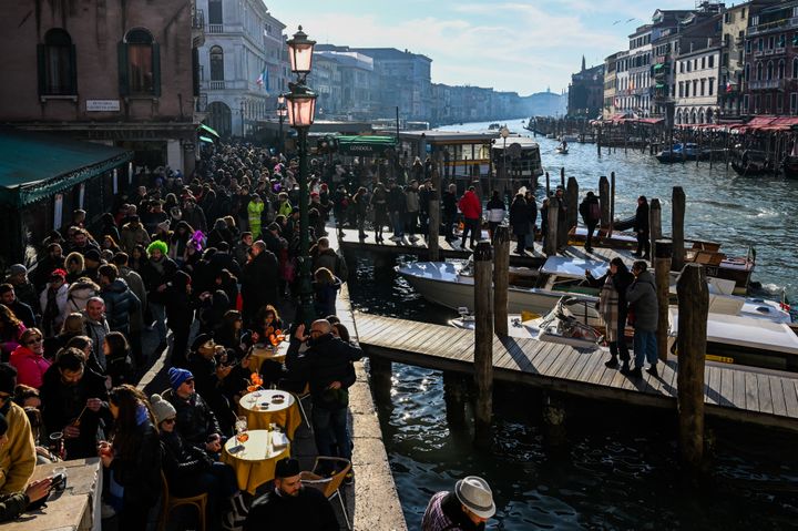 Visitatori e turisti si riuniscono vicino al Canal Grande durante il Carnevale di Venezia l'11 febbraio 2023. Il 14 settembre 2023 l'ONU ha dichiarato di non aver inserito Venezia, una delle principali destinazioni turistiche del mondo, nella sua lista del patrimonio mondiale "in pericolo" (MIGUEL MEDINA/AFP)