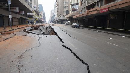 La chaussée est fendue, au lendemain de l'explosion dans une rue de Johannesburg (Afrique du Sud), le 19 juillet 2023. (LUCA SOLA / AFP)