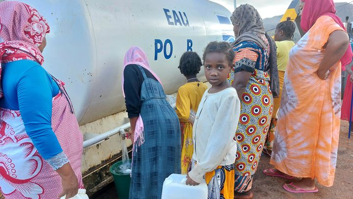 Un enfant mahorais vient remplir un bidon à la citerne installée à Hajangua, le 25 décembre. (AGATHE MAHUET / FRANCE INFO / RADIO FRANCE)