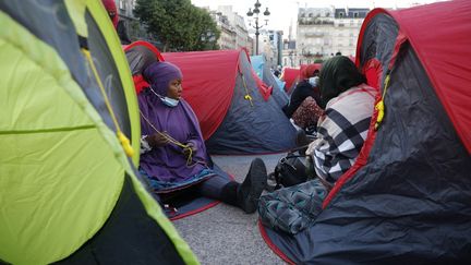 Des migrants installent des tentes devant l'Hôtel de Ville de Paris, le 24 juin 2021, lors d'une opération organisée par l'association Utopia56. (GEOFFROY VAN DER HASSELT / AFP)