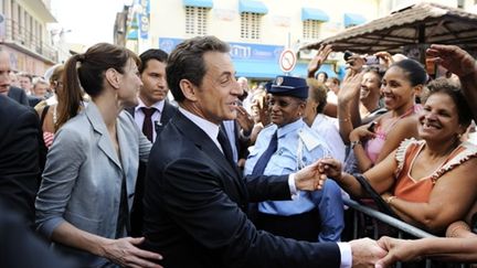 Nicolas Sarkozy et son épouse Carla Bruni-Sarkozy dans les rues de Port-de-France, le 8 janvier 2011. (AFP - Eric Feferberg)