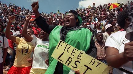 Des milliers de personnes assistent le 12 f&eacute;vrier 1990 &agrave; son premier meeting apr&egrave;s sa sortie de prison, au stade Orlando de Soweto. "Enfin libre", peut-on lire sur cette pancarte. (PHILIP LITTLETON / AFP)