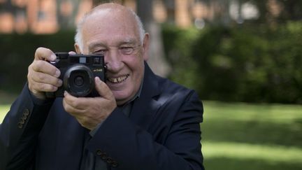 Le photographe Raymond Depardon pose avec son appareil à Bogota, en Colombie. 
 (EITAN ABRAMOVICH / AFP)