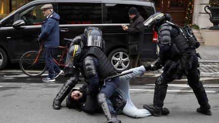 Trois membres des forces de l'ordre interpellent de façon musclée un manifestant lors de la manifestation à Paris, le 8 décembre 2018.&nbsp; (MAXPPP)