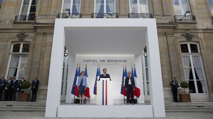 Emmanuel Macron, entouré par les ministres Florence Parly (à gauche) et&nbsp;Genevieve Darrieussecq (à droite), samedi 13 juillet 2019 à Paris. (KAMIL ZIHNIOGLU / AFP)