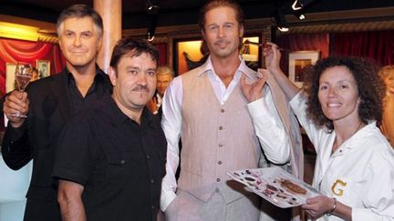 French sculptor Stephane Barret (2ndL) and a makeup artist (R) pose with the wax figures of US actors George Clooney (L) and Brad Pitt at the Grevin wax museum in Paris on July 26, 2011. AFP PHOTO FRANCOIS GUILLOT
 (AFP / FRANCOIS GUILLOT)