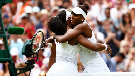 Les s&oelig;urs Williams (Serena &agrave; gauche, Venus &agrave; droite) s'&eacute;treignent apr&egrave;s leur match des 16es de finale &agrave; Wimbledon, le 6 juillet 2015. (JULIAN FINNEY / GETTY IMAGES SPORT)