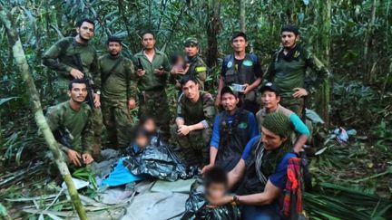 Des membres de l'armée posent avec quatre enfants indigènes qui ont été retrouvés vivants après avoir passé plus d'un mois perdus dans la jungle amazonienne colombienne, à la suite du crash d'un petit avion, le 9 juin 2023. (HANDOUT / COLOMBIAN PRESIDENCY / AFP)