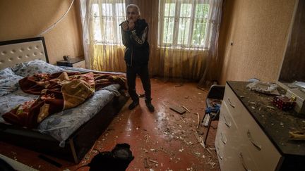 Un résident local montre un trou dans le sol endommagé par les récents bombardements dans sa maison, dans la ville d'Ivanyan, à l'extérieur de Stepanakert, la République autoproclamée du Haut-Karabakh, le 1er octobre 2020. (ASATUR YESAYANTS / SPUTNIK / AFP)