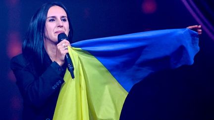 La chanteuse ukrainienne, lauréate de l'Eurovision 2016, revêtue du drapeau ukrainien, lors de sa prestation aux prélimainaires du concours le 4 mars 2022, à Berlin.&nbsp; (BRITTA PEDERSEN / DPA-POOL)