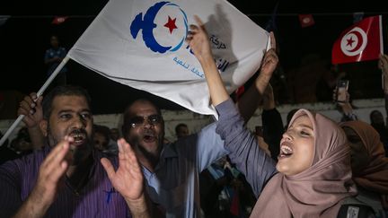 Partisans de la formation d'inspiration islamiste Ennahdha à Tunis le 6 octobre 2019 sur arrière-fond de drapeau nahdaoui (à gauche) et tunisien (à droite). (RIADH DRIDI/AP/SIPA / SIPA)